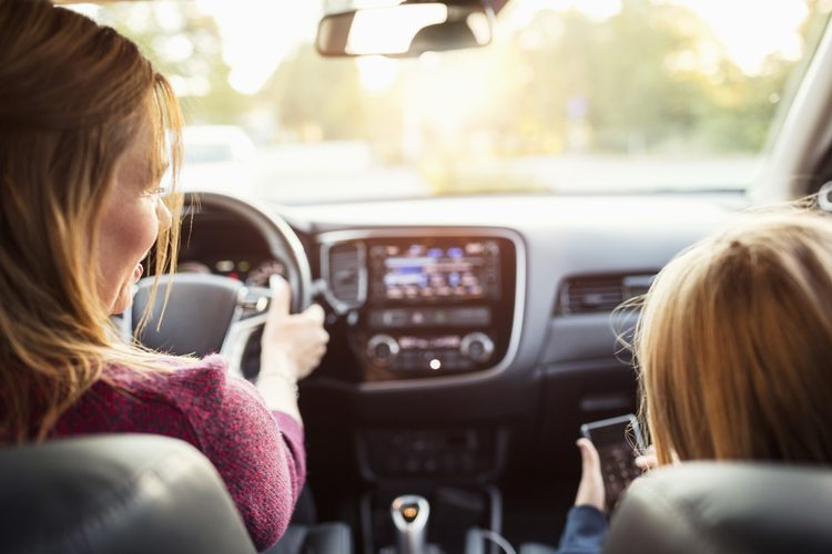 A driver in a car with a child next to them