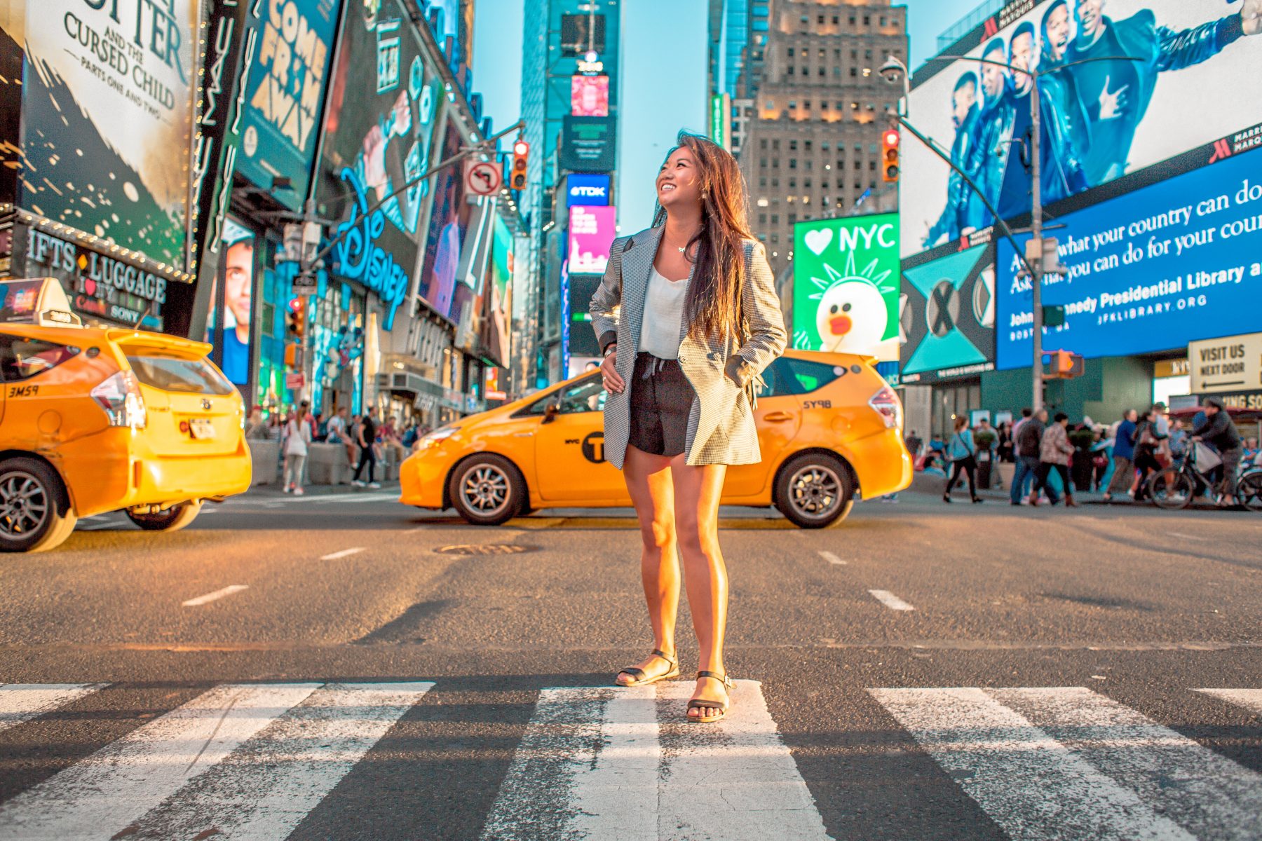 Person smiling and standing in Time Square NYC