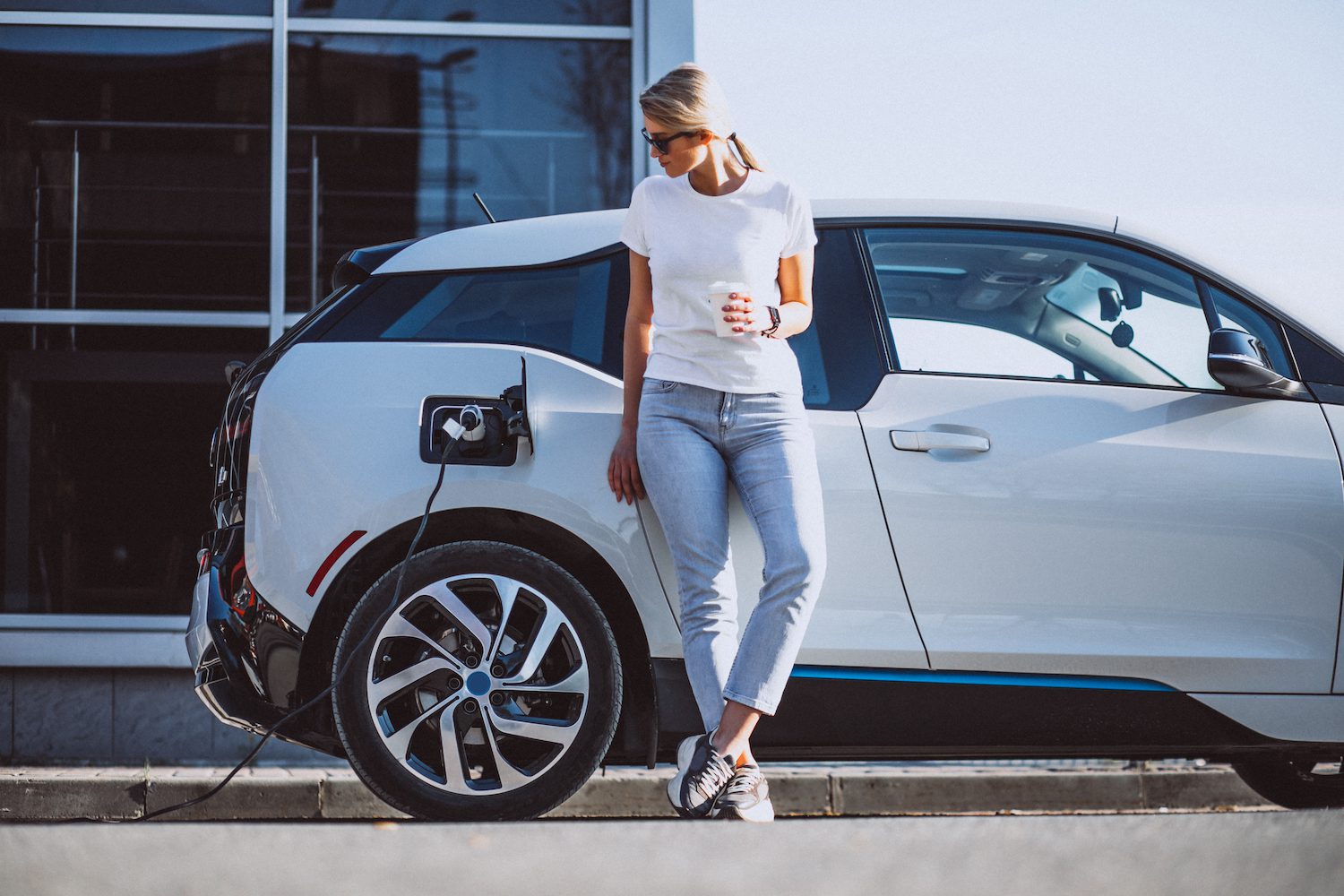 Person standing next to electric car charging