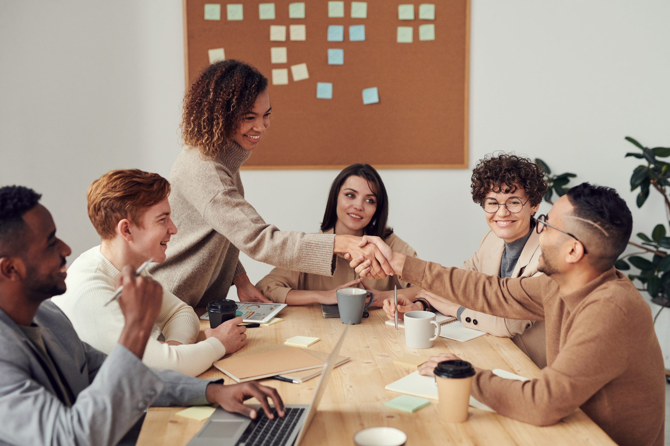Connected car essentials - why WirelessCar A group of people around a table smiling and shaking hands