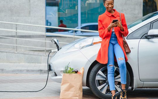 Smart EV Routing person charging her electric vehicle