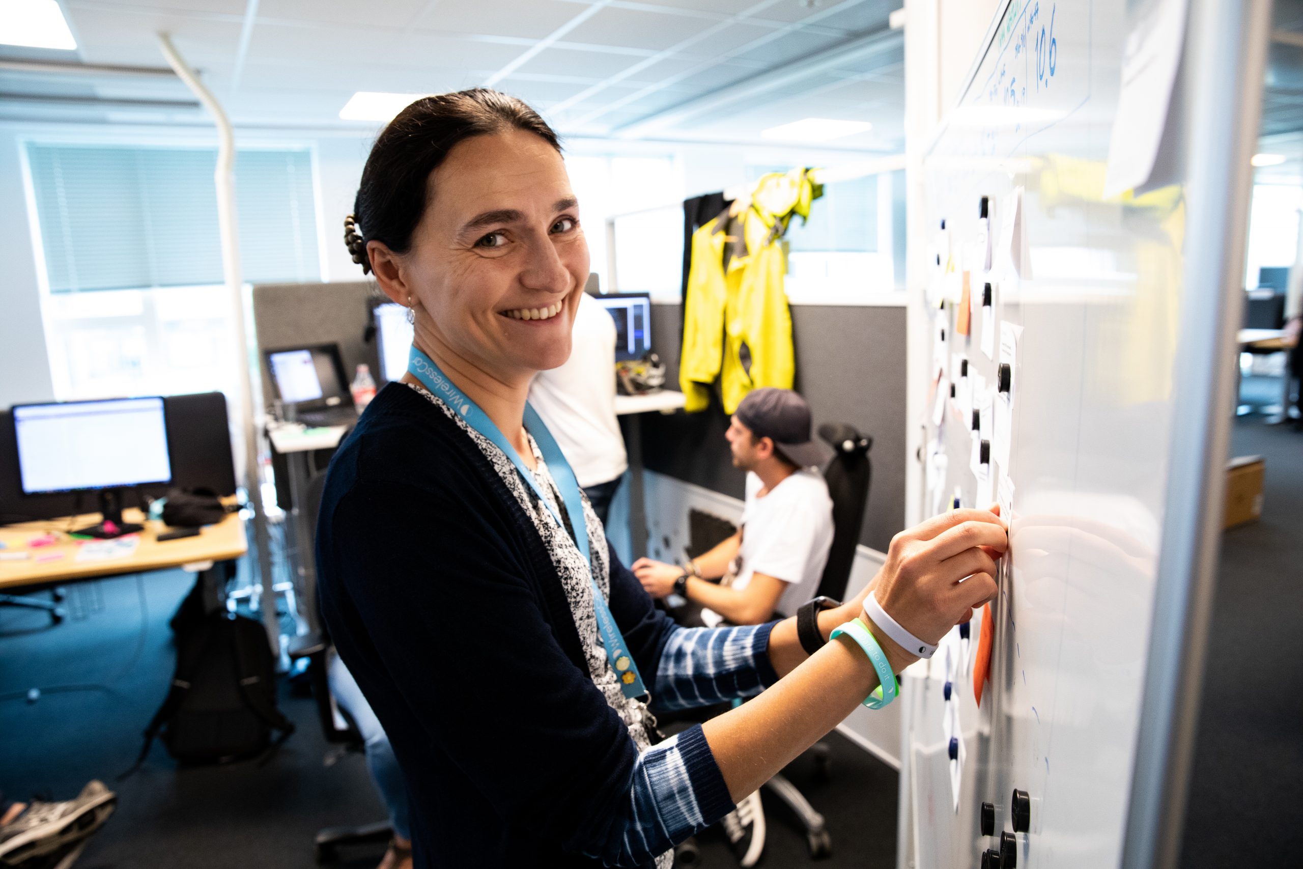 Smiling woman standing next to a white board