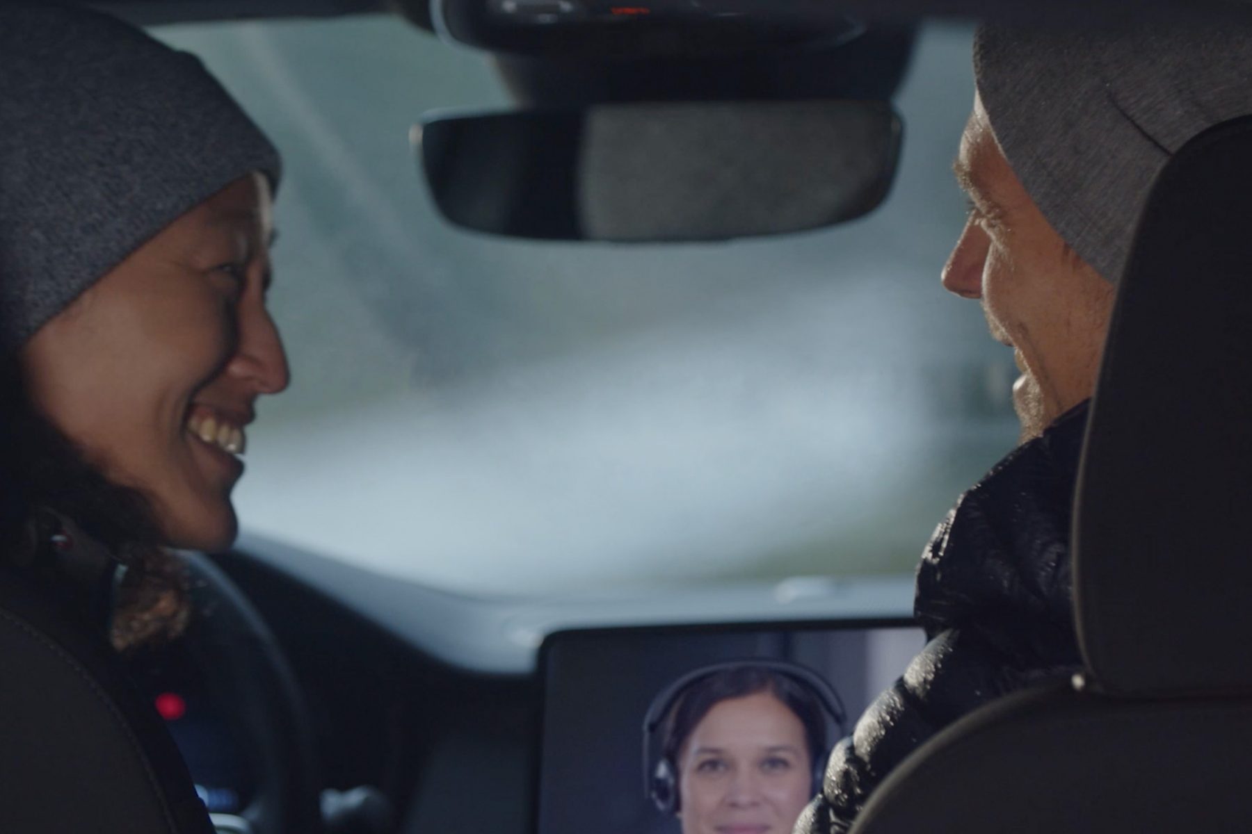 Call Center Services Two people facing each other smiling in front seat of car