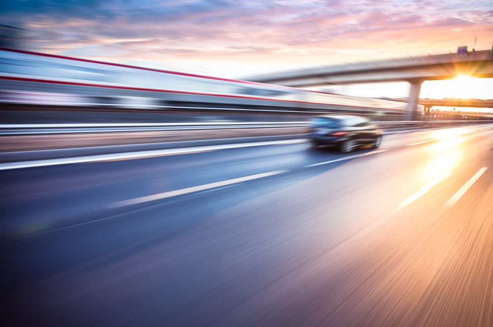 Car,Driving,On,Freeway,At,Sunset,,Motion,Blur