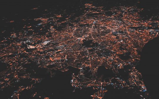 An aerial view of a city at night with city lights
