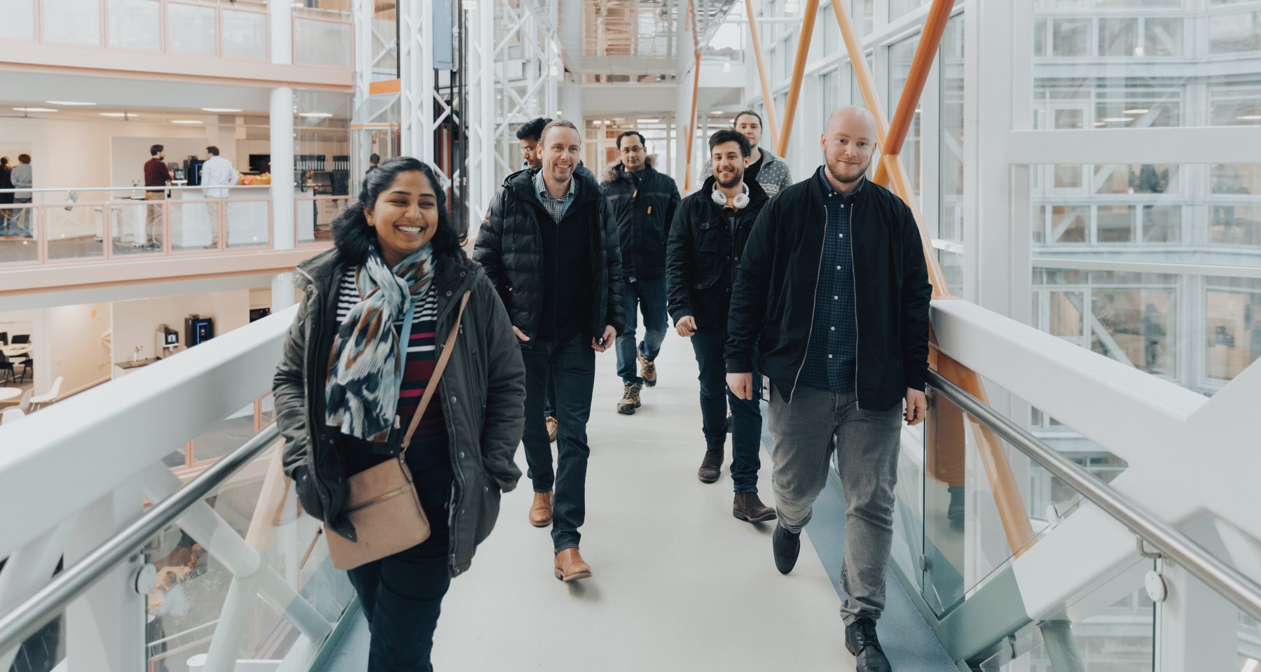 a group of smiling people walking in the office