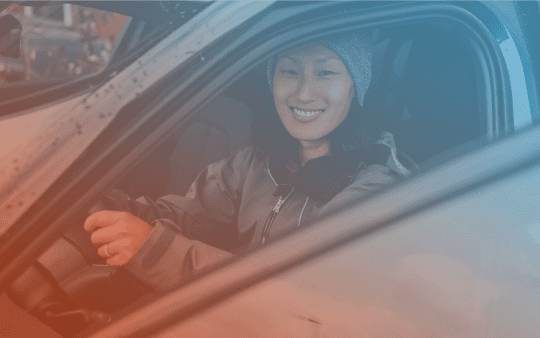 a smiling woman sitting in a car