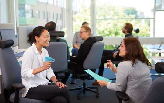 two women talking to each other in an office