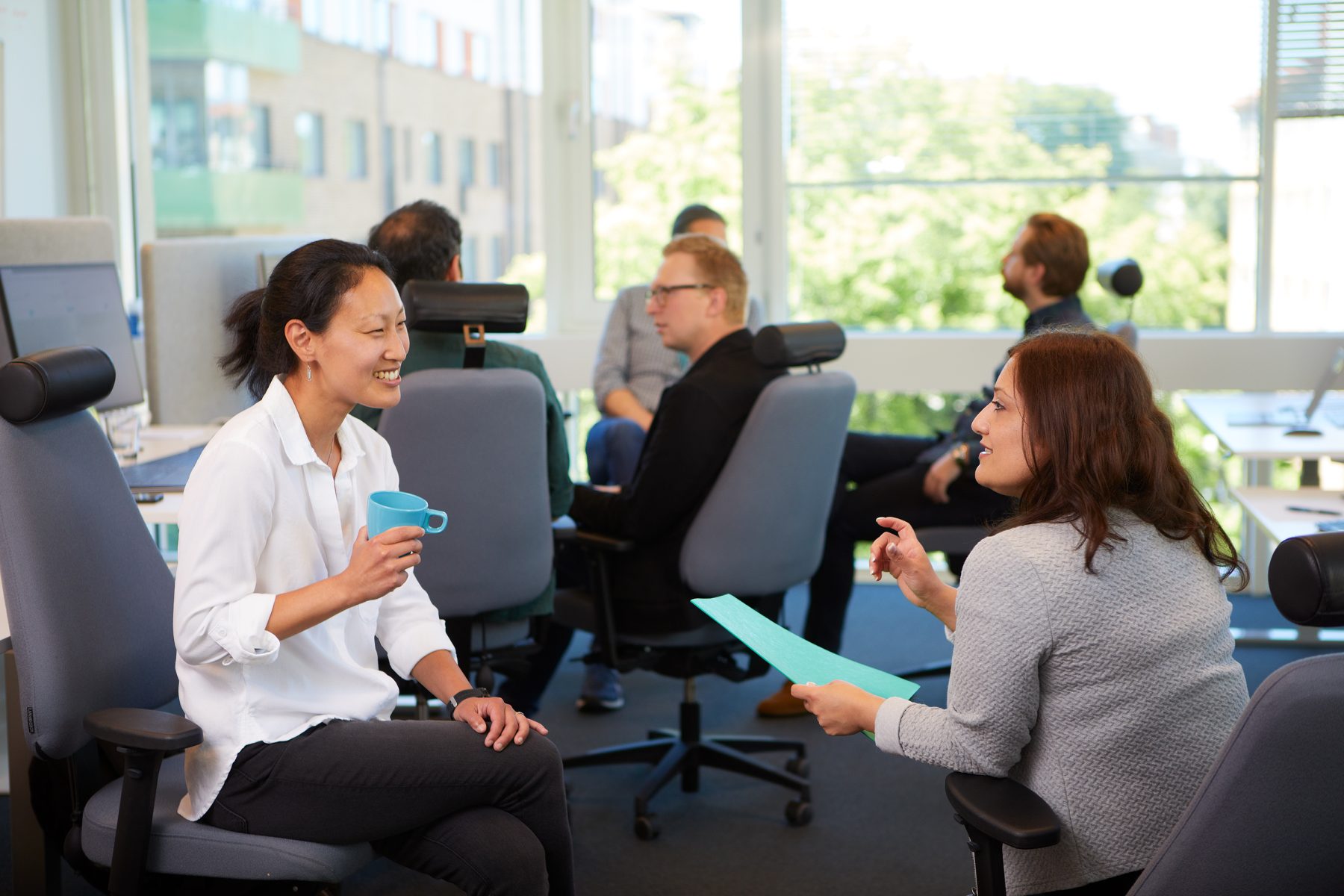 two women talking to each other in an office