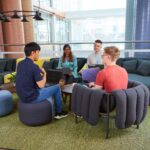 a group of people talking to each other in an office