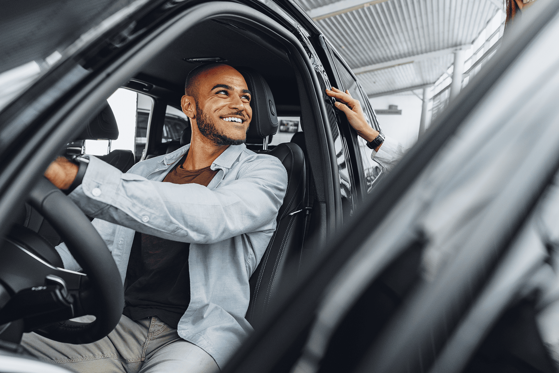 smiling man sitting in his electric vehicle