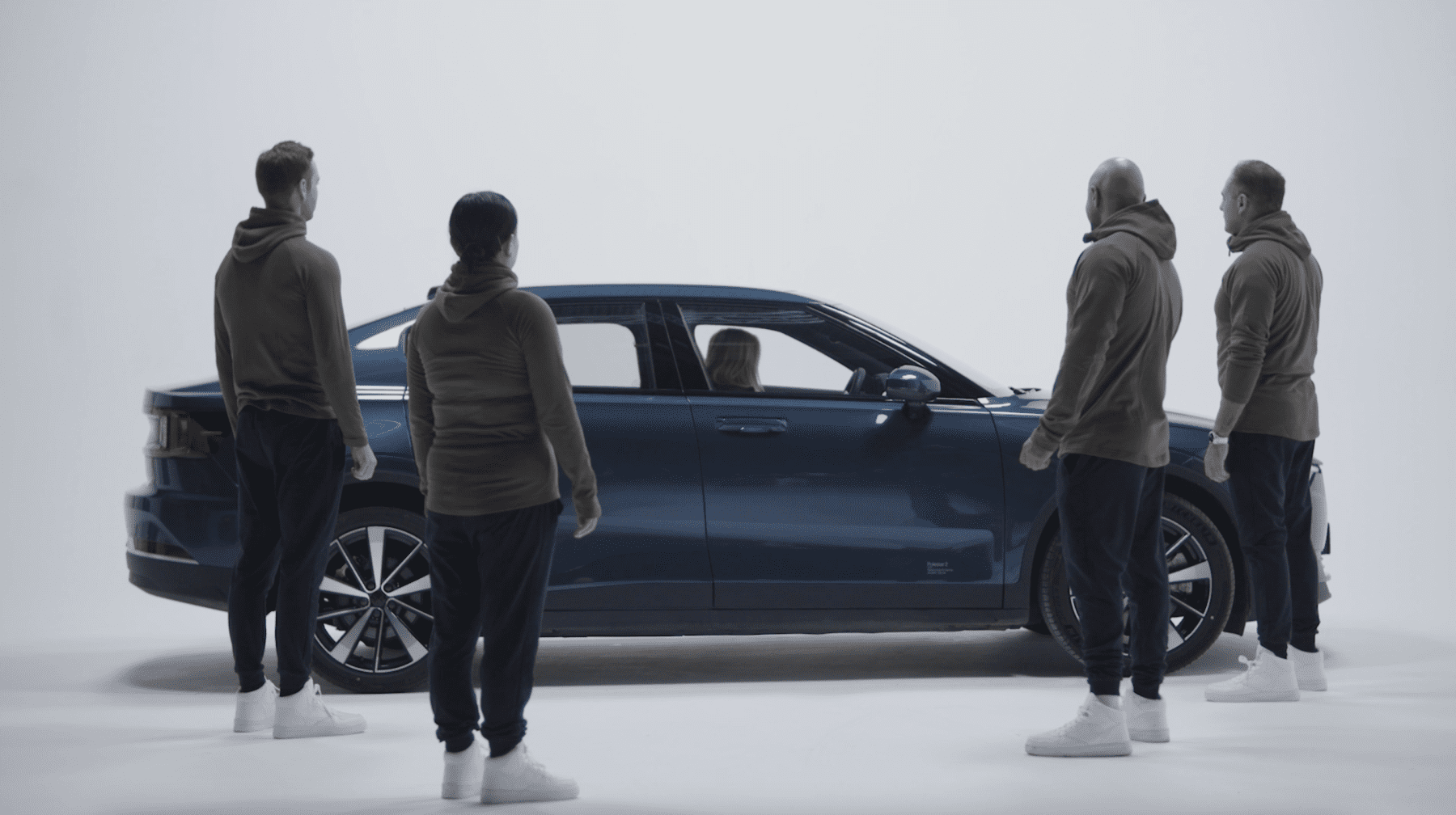 a group of people standing around a car