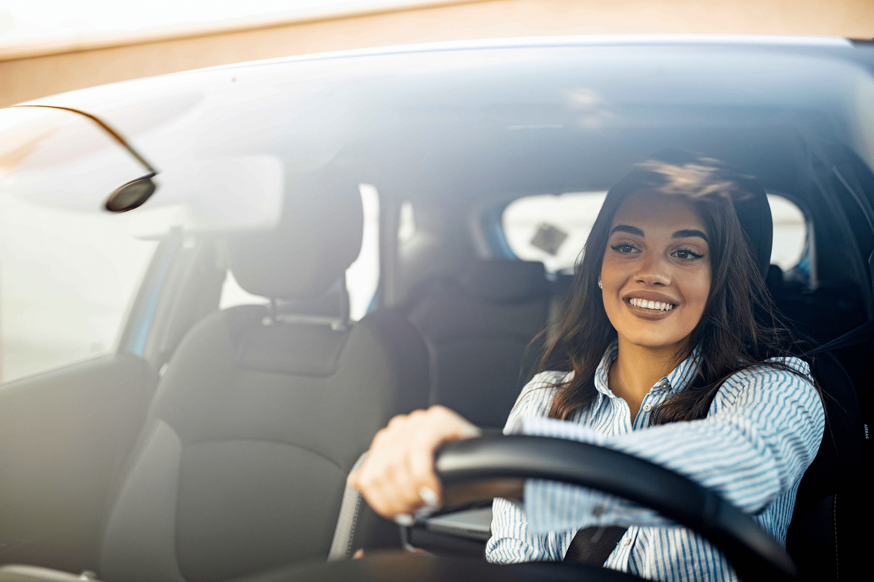 a happy woman driving a car