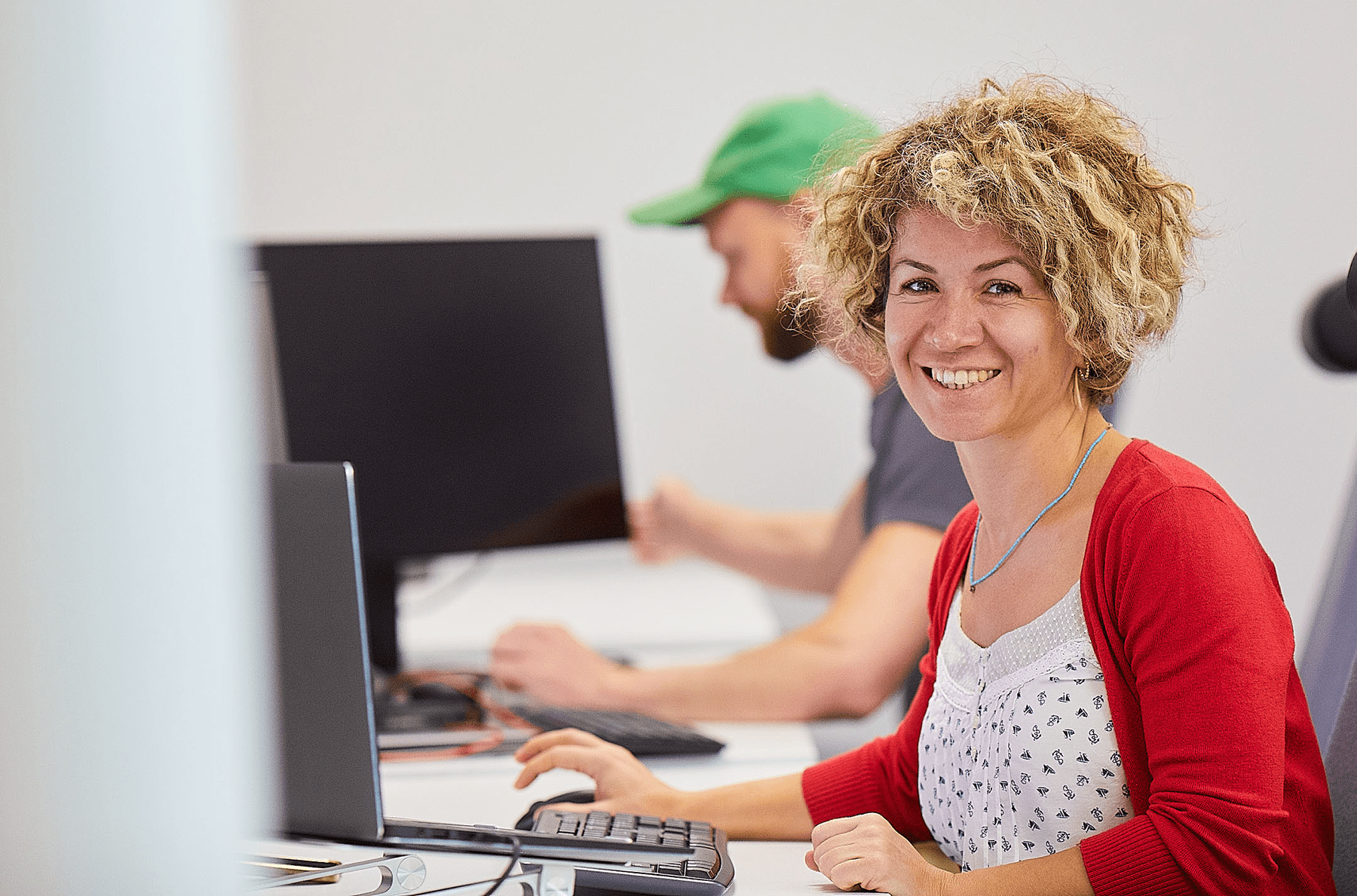 a smiling woman in front of a computer screen