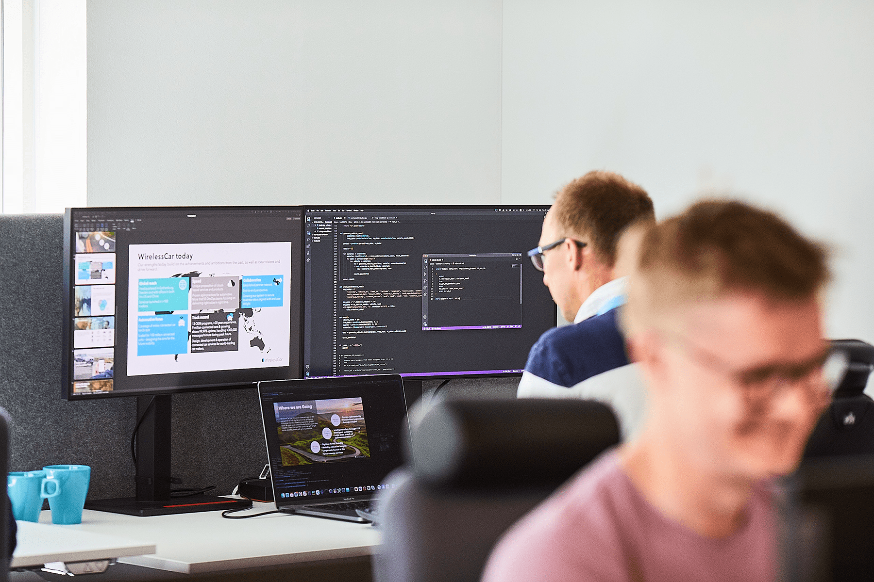 a man in front of two screens, coding