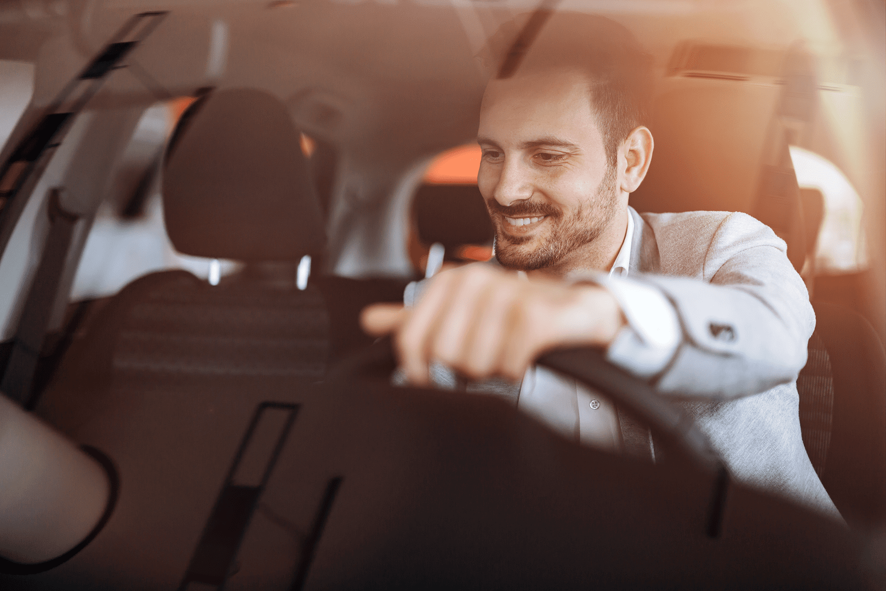 a happy businessman driving a car