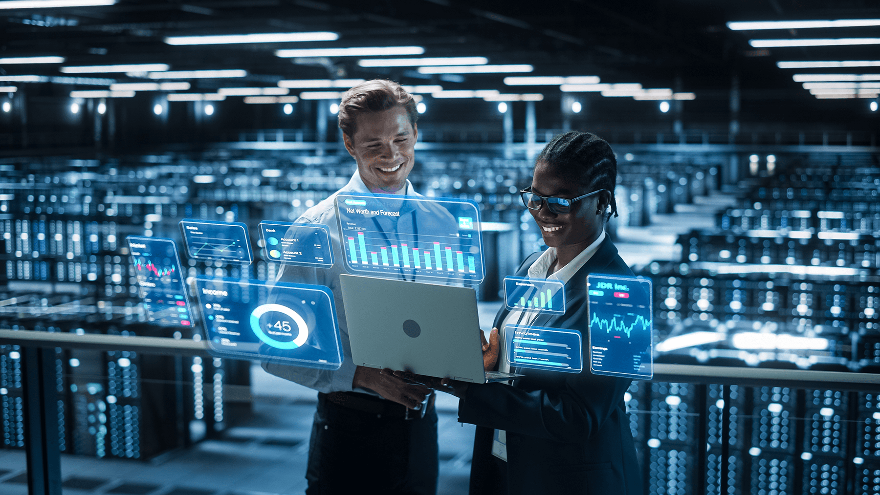 a man and a woman smiling and using a computer in a modern data center