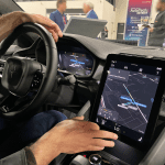 man sitting inside a modern car displaying a demo