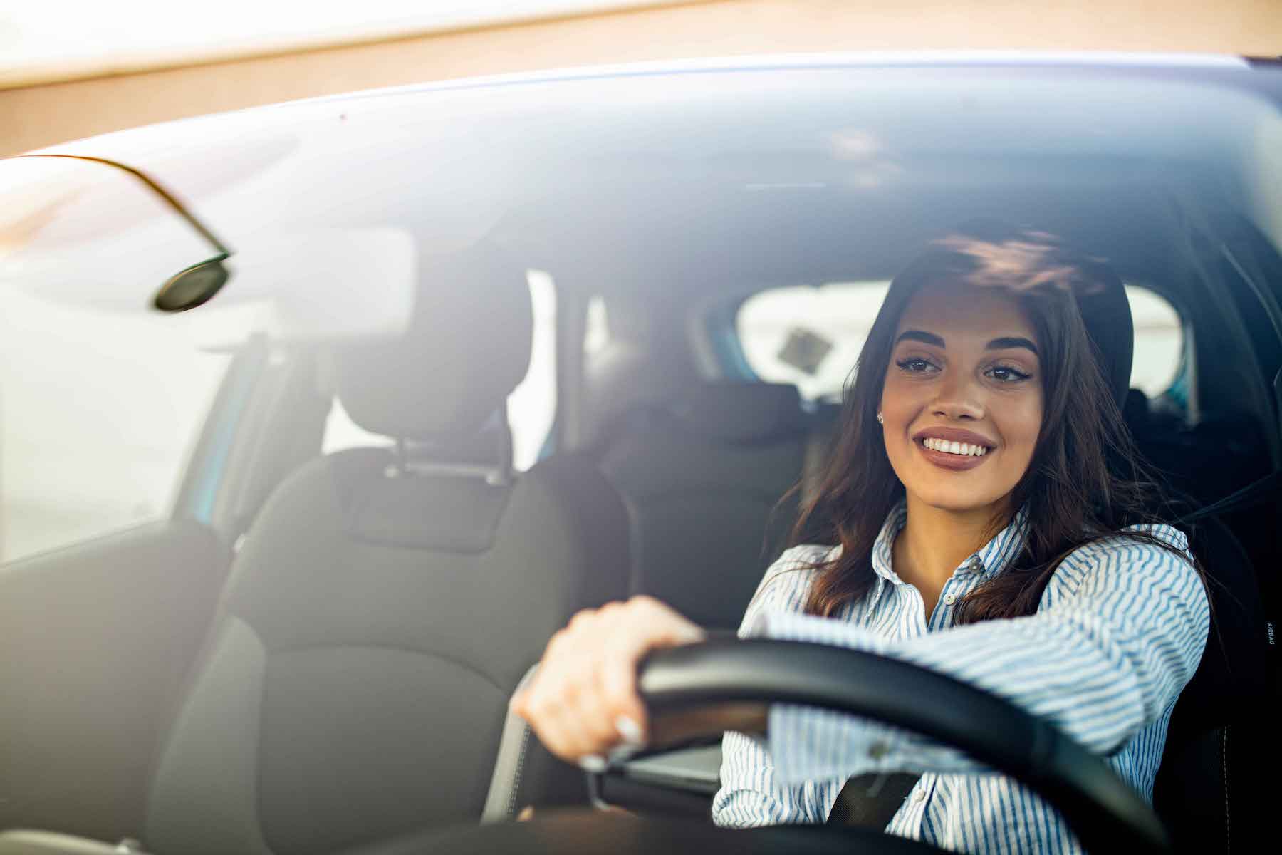 A happy woman driving a car