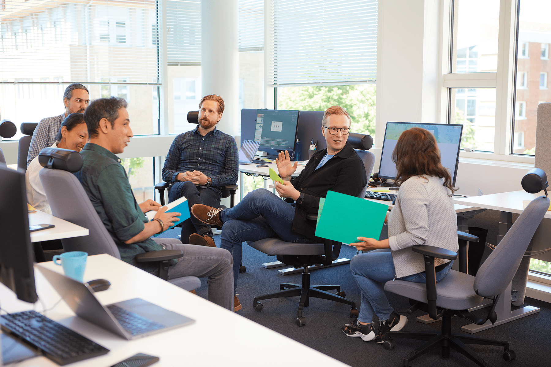 a group of people sitting in the office and talking