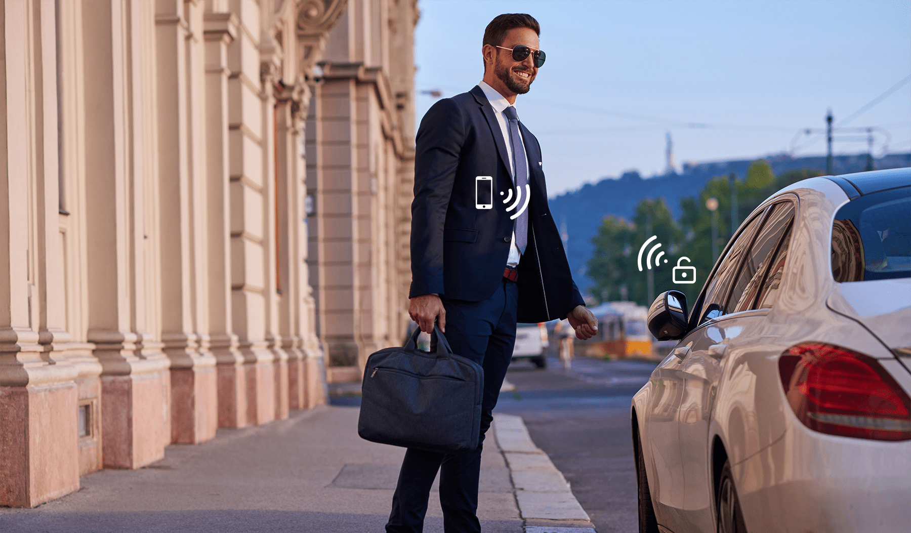 A happy businessman standing next to a sleek white car