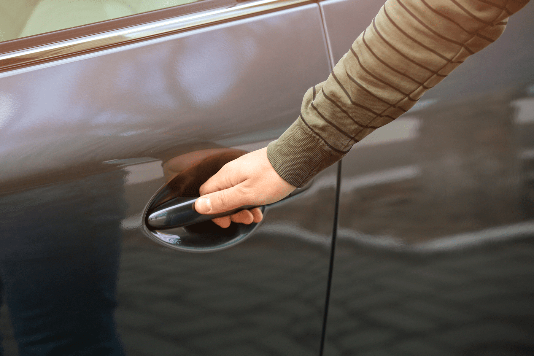 a hand opening a car door