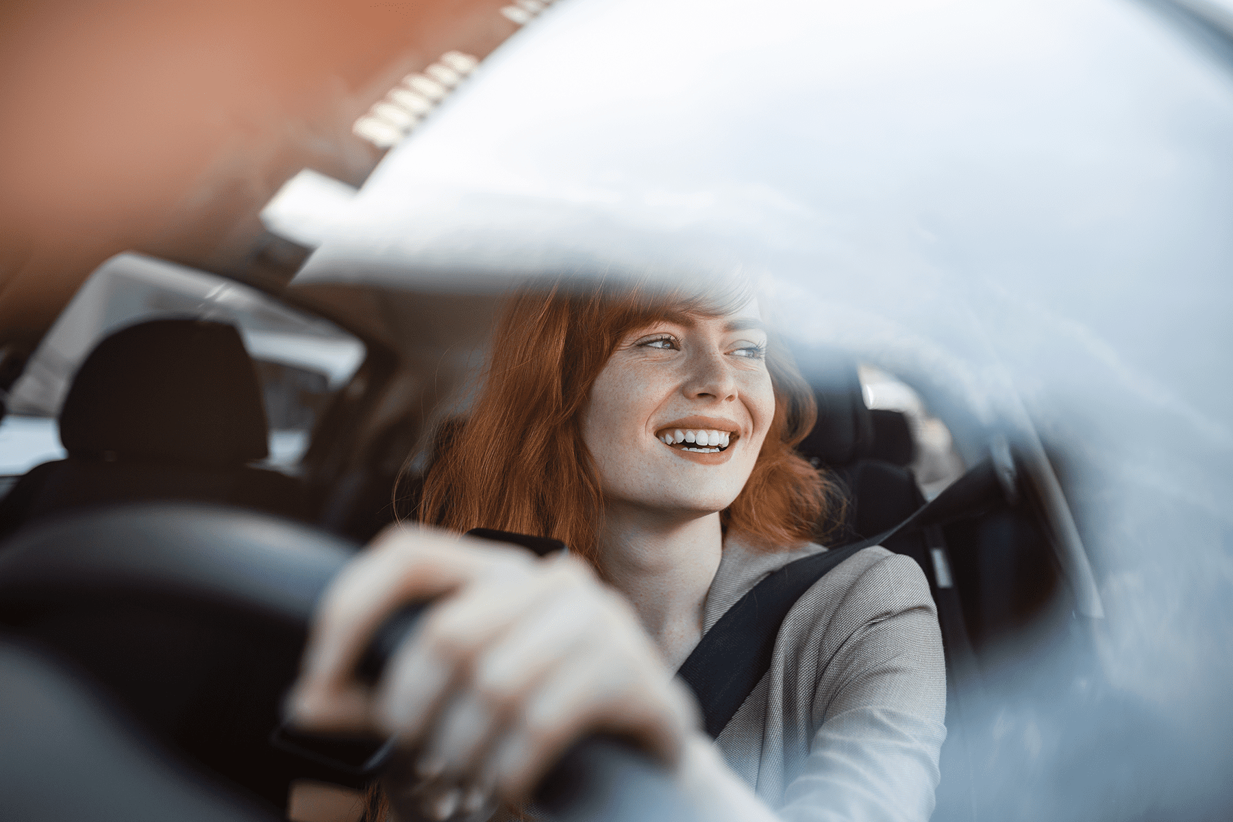 a happy woman driving a car